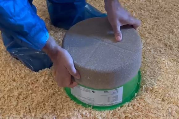 Farmer a PECKStone pecking block on top of green container